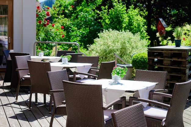 Straßenrestaurant mit Tischen und Stühlen im Hotelresort in Bad Kleinkirchheim in Kärnten, Österreich. Design des Straßencafés. Lebensstil und Natur. Terrasse oder Veranda des Cafés zum Frühstück bereit
