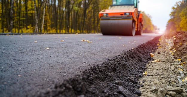 Straßenwalze, die neuen Asphalt abflacht Schwere Vibrationswalze bei der Arbeit, die Asphaltstraßen repariert, selektiver Fokus