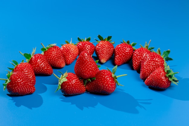 Strauß Erdbeeren an blauer Wand