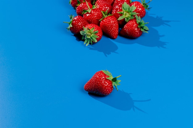 Strauß Erdbeeren an blauer Wand