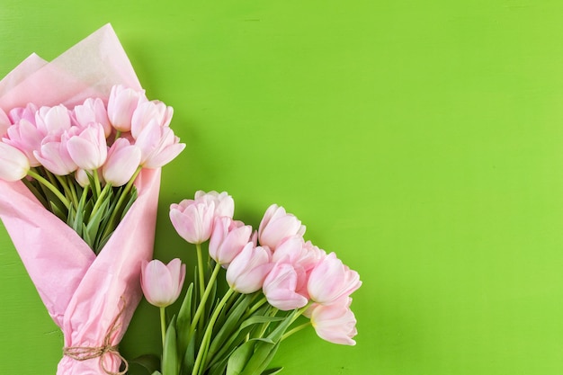 Strauß rosa Tulpen auf grünem Hintergrund.