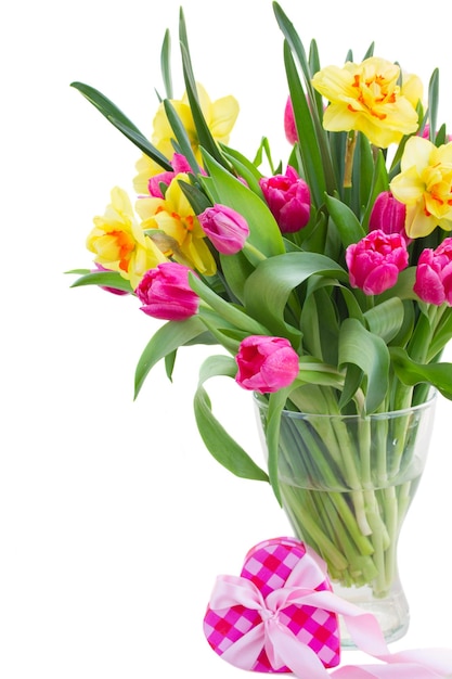 Strauß rosafarbener Tulpenblumen und gelber Narzissen in Vase mit rosafarbener Geschenkbox isoliert auf weißem Hintergrund