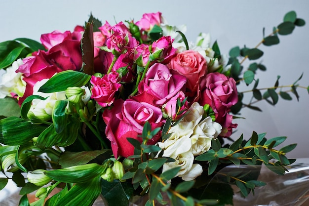 Strauß Rosen, weiße Blumen und viel Grün Schließen