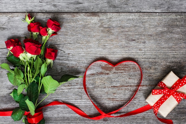 Strauß roter Rosen und herzförmiges rotes Band