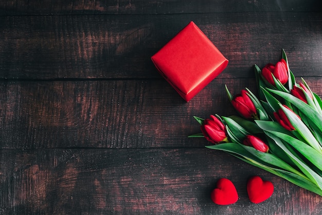 Strauß roter Tulpen auf einem hölzernen Hintergrund. Frühlingsblumen. Muttertag Hintergrund.