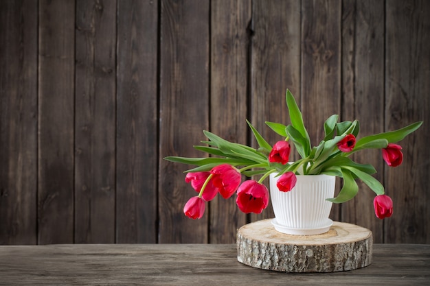 Strauß roter Tulpen auf hölzernem Hintergrund