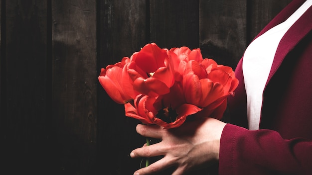 Strauß roter Tulpen in weiblichen Händen