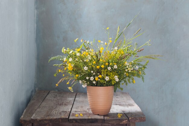 Strauß wilder Blumen auf altem Holztisch