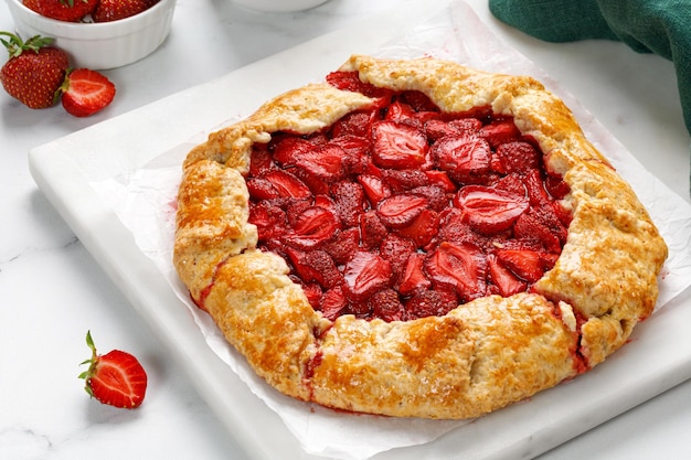 Strawberry galette Offener Erdbeerkuchen auf Marmorplatte Hausgemachter Gebäck gebackener Kuchen mit Erdbeere