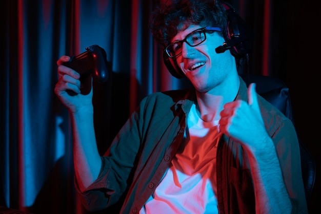 Streamer sonriente ganando con joystick centrando el equipo de Esport en la PC Gusher