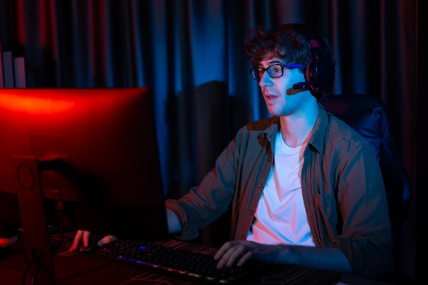 Streamer sonriente con joystick enfocando el equipo de Esport en la PC con Gusher más duro