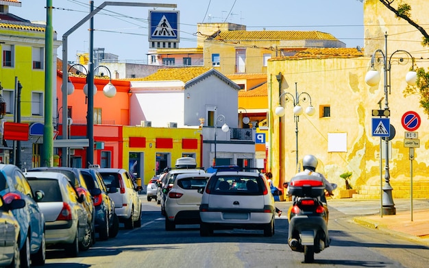 Street Cityscape de motocicleta na estrada na cidade de Cagliari, no sul da Sardenha, na Itália. Homem na scooter na pequena cidade italiana da Sardenha na Sardenha. Distrito urbano. Província. Mídia mista.