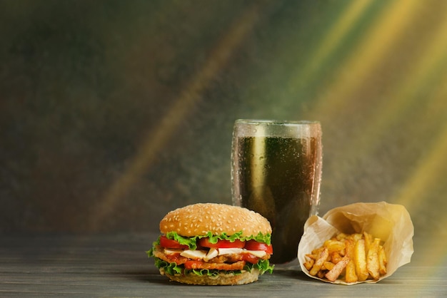 Street Food oder Fast Food Hamburger Pommes Frites und Cola auf dem Tisch mit Holzhintergrund Ungesunde Burger mit Rindfleisch