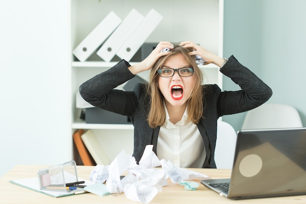 Stress, Büro, Hysterik, Menschenkonzept - aggressive Frau mit viel Arbeit im Büro lachen wegen Hysterik.