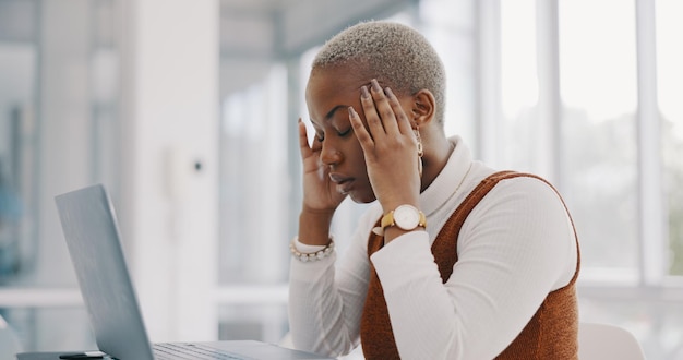 Stress-Burnout und Kopfschmerzen einer schwarzen Frau auf dem Laptop, die im Büro einer Marketingfirma E-Mails tippt. Angst, müde und Migräne von Mitarbeitern, die frustriert an professionelle Online-Antworten denken