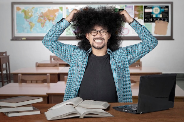 Stressiger Student, der sich im Unterricht an den Haaren zieht