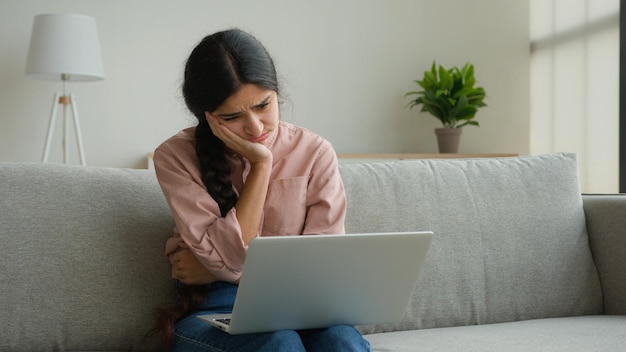 Stressvolle arabische Frau, Geschäftsfrau, Studentin, Freiberuflerin, die schlechte Nachrichten liest, auf den Laptop schaut und empfängt