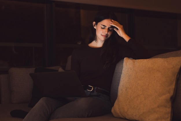 Stressvolle Frau spät in der Nacht mit starken schrecklichen Kopfschmerzen Anfall nach Computer Laptop Studium schläfrig erschöpft Mädchen leidet an chronischer Migräne Massage Tempel, um Kopfweh Spannung zu lindernxA