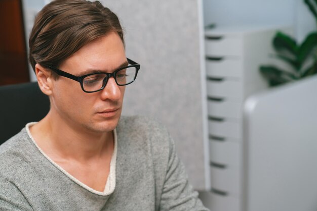 Stressvoller Büroangestellter konzentriert sich auf den Geschäftsbericht auf dem PC