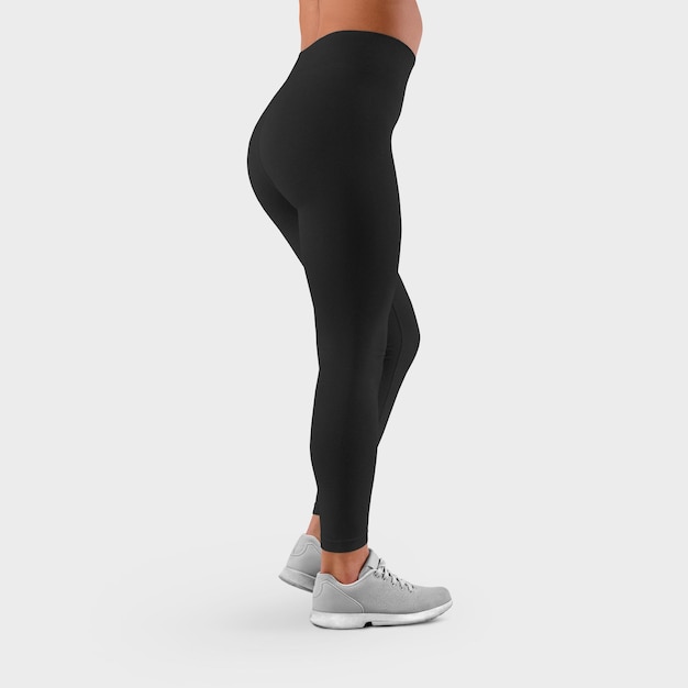 Stretch-Hose auf den schlanken Beinen eines Mädchens in Turnschuhen auf Hintergrund isoliert Schwarze Leggings