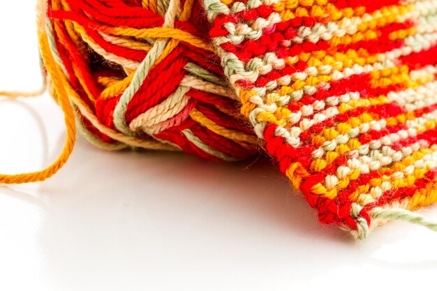 Stricken mit mehrfarbigem Garn mit Orange-, Rot- und Gelbtönen.