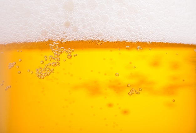 Strömendes Bier mit Blasenschaum im Glas für Hintergrund