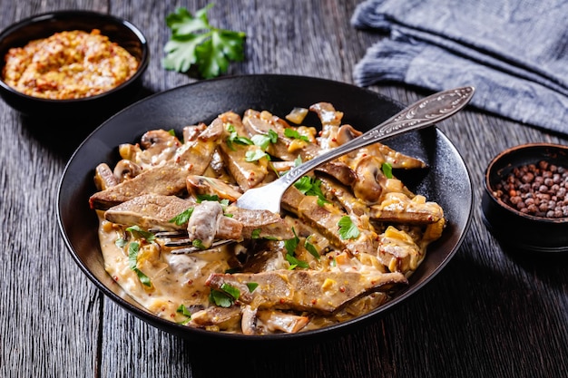 Stroganoff de fígado em uma tigela preta vista de cima