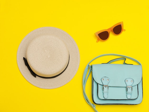 Strohhut der Frau mit Handtasche und Sonnenbrille