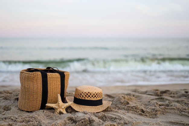 Strohhut, Tasche, Seestern auf dem schönen Sand am Meer