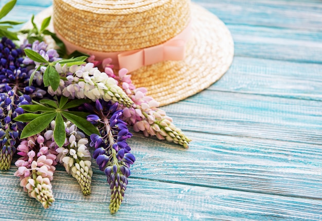 Strohhut und Lupinenblüten