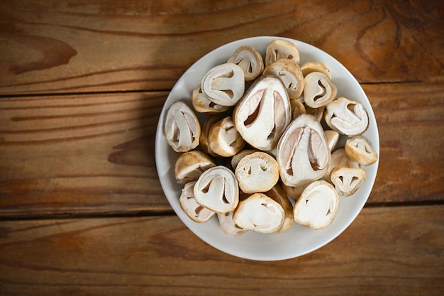 Strohpilze auf weißer Platte frische Pilze schneiden zum Kochen von Draufsicht