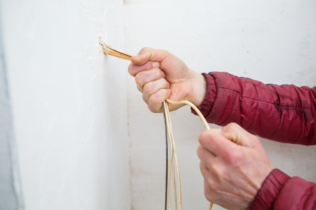 Strominstallation. Während der Reparatur. öffne die Drähte. Herausragend isoliert auf einer weißen Wand. Professionelle Installation elektrisch