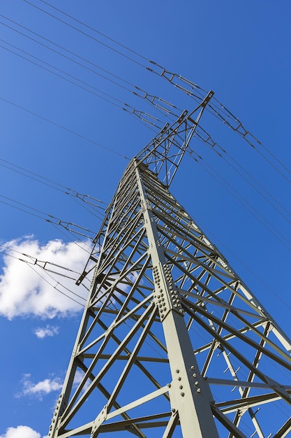 Strommast am blauen bewölkten Himmel Industriehochspannung