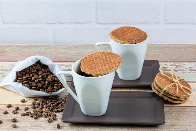 Stroopwafel-Kekse serviert mit Tassen Kaffee.