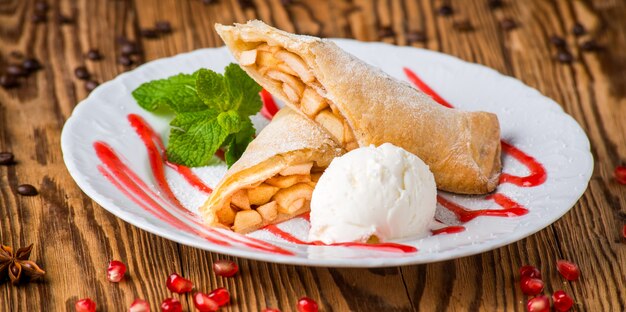 Strudel de maçã polvilhado com açúcar em pó e sorvetes