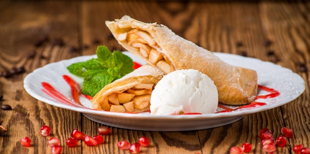 Strudel de maçã polvilhado com açúcar em pó e sorvetes