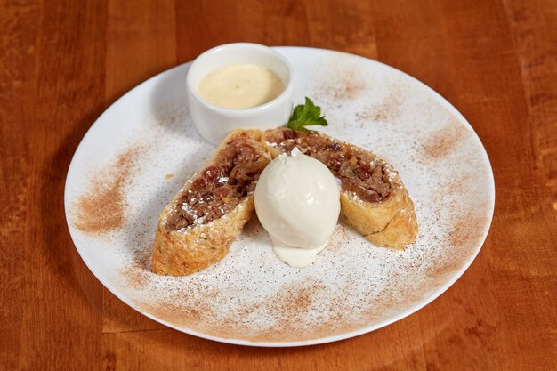 Strudel de manzana con bola de helado en un plato