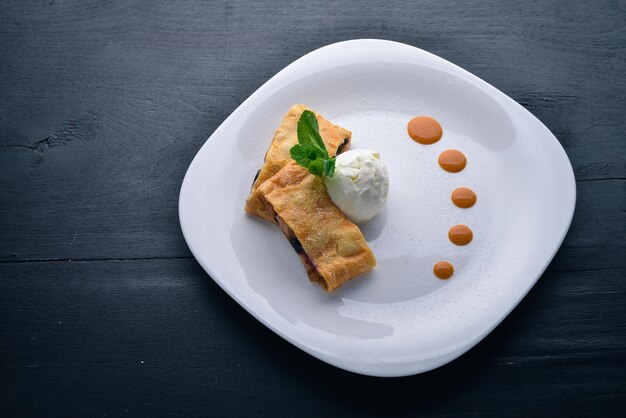 Strudel de manzana con helado Sobre un fondo de madera Vista superior Espacio libre para el texto