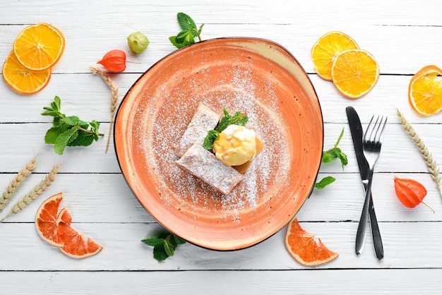 Strudel con manzanas y helado en un plato Postre Sobre un fondo de madera Espacio de copia libre Vista superior