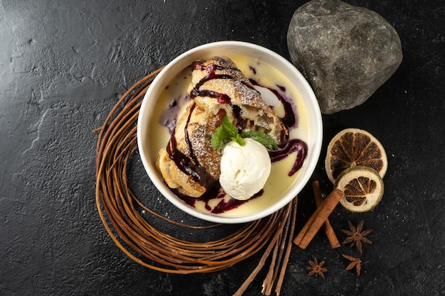 Strudel mit Eis. Klassisches süßes Dessert mit Beerensauce und Vanilleeis