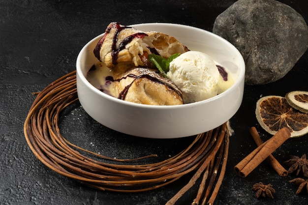 Strudel mit Eis. Klassisches süßes Dessert mit Beerensauce und Vanilleeis