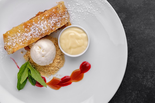 Strudel de postre con manzanas y helado sobre un fondo oscuro