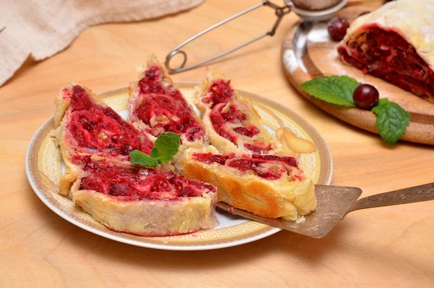 Strudel vienés casero en rodajas con relleno de cereza en un plato