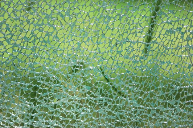 Strukturierter Hintergrund, zerbrochenes blaues Glas mit Rissen sieht aus wie ein Netz