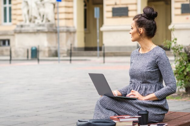 Student benutzt Laptop auf der Bank