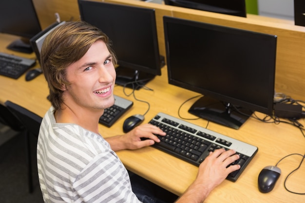 Student, der an Computer im Klassenzimmer arbeitet