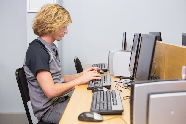 Student, der an Computer im Klassenzimmer arbeitet