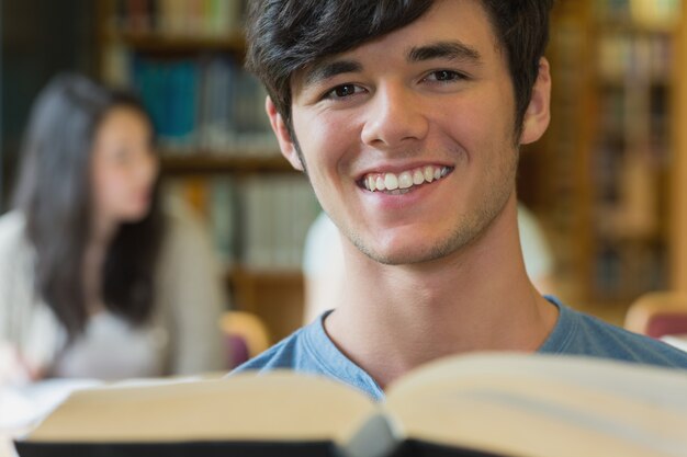 Student, der an der Bibliothek liest ein Buch sitzt