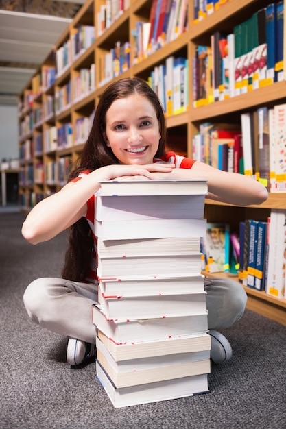 Student, der auf Boden in der Bibliothek sitzt