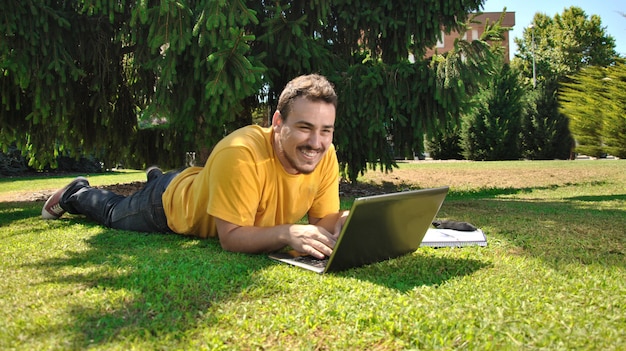 Student, der auf dem Gras in der Sonne liegt